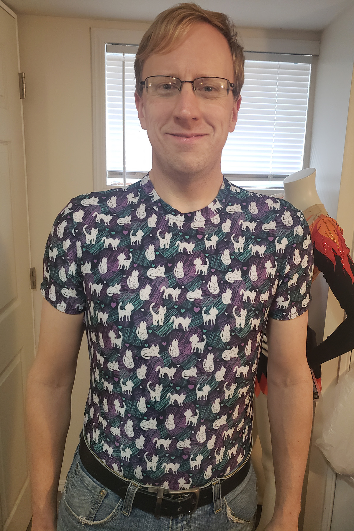 A middle aged blond man wearing a cat print spandex shirt.