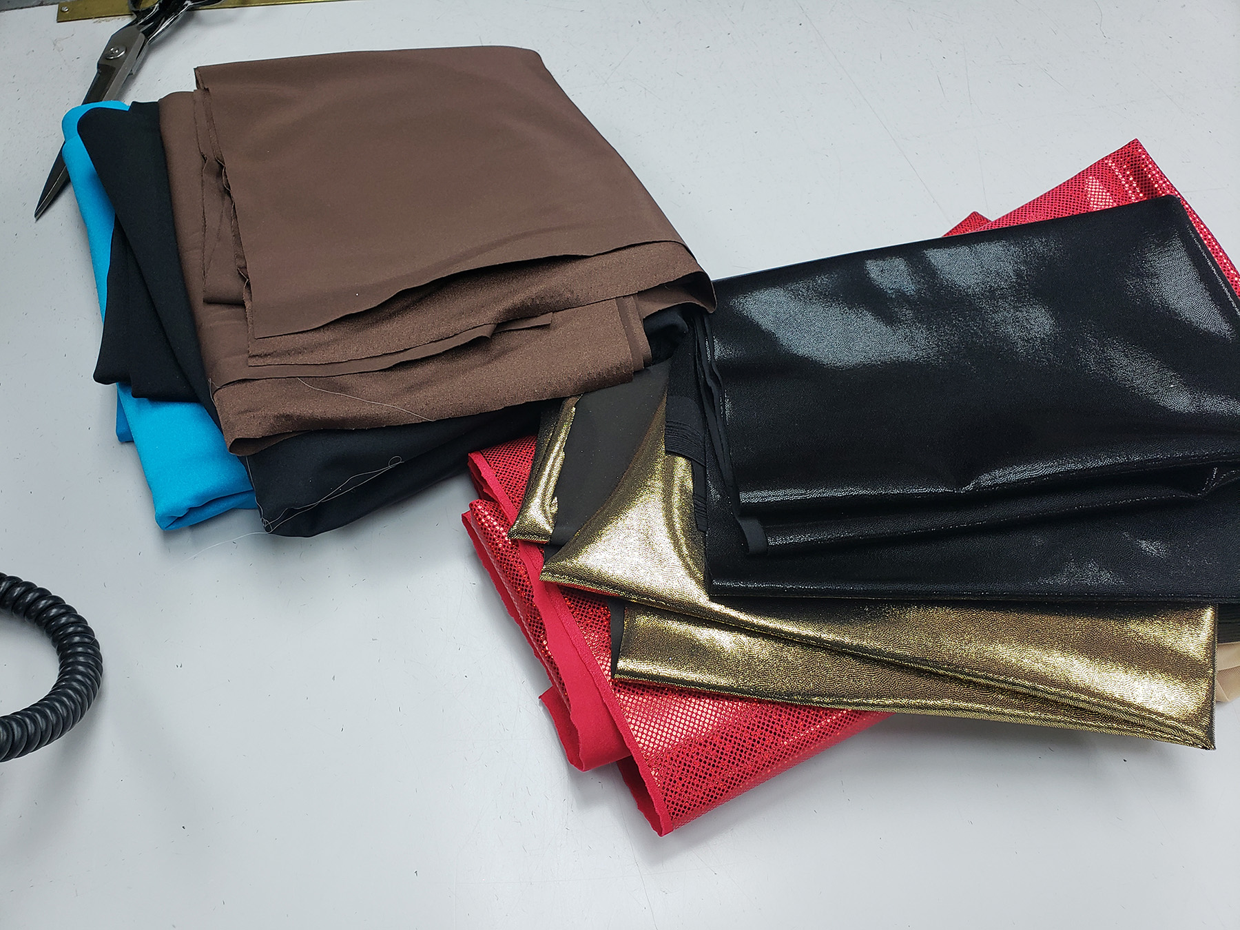 A pile of brown, black, gold, and red spandex fabric.