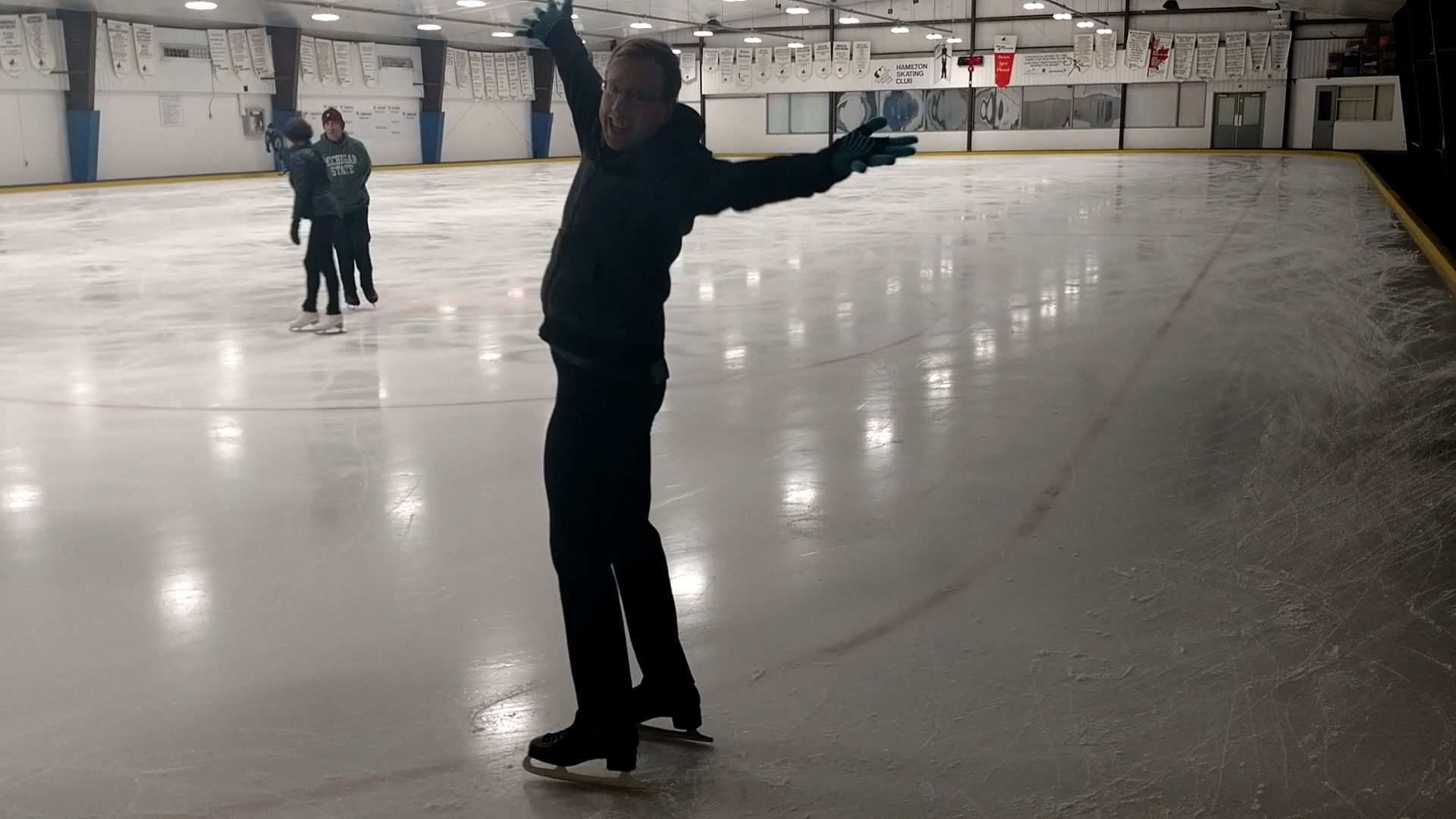 A middle aged blonde male figure skater posing on the ice