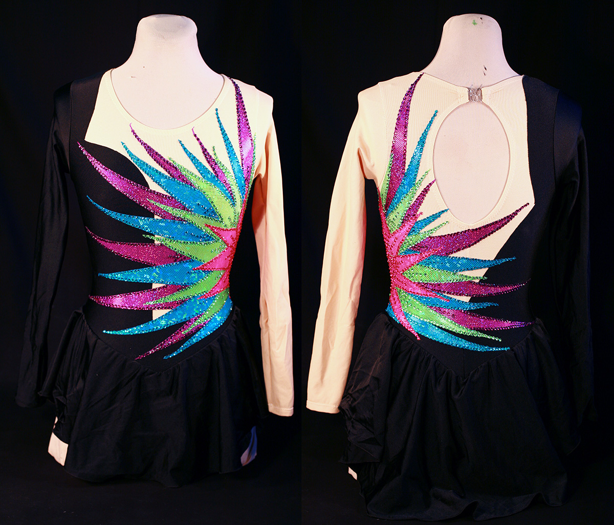 Front and back views of a black and beige skating dress with a pink, green, and purple starburst design on one side.