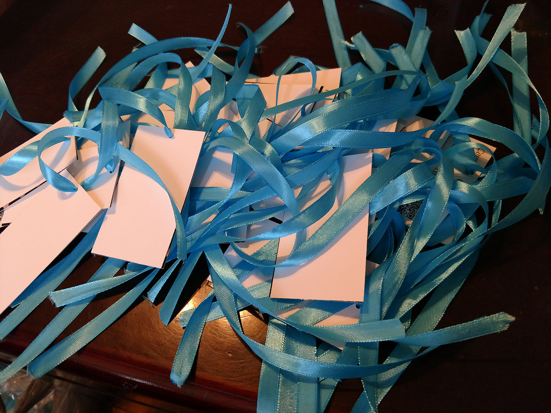 A pile of white cards tied with blue ribbons.