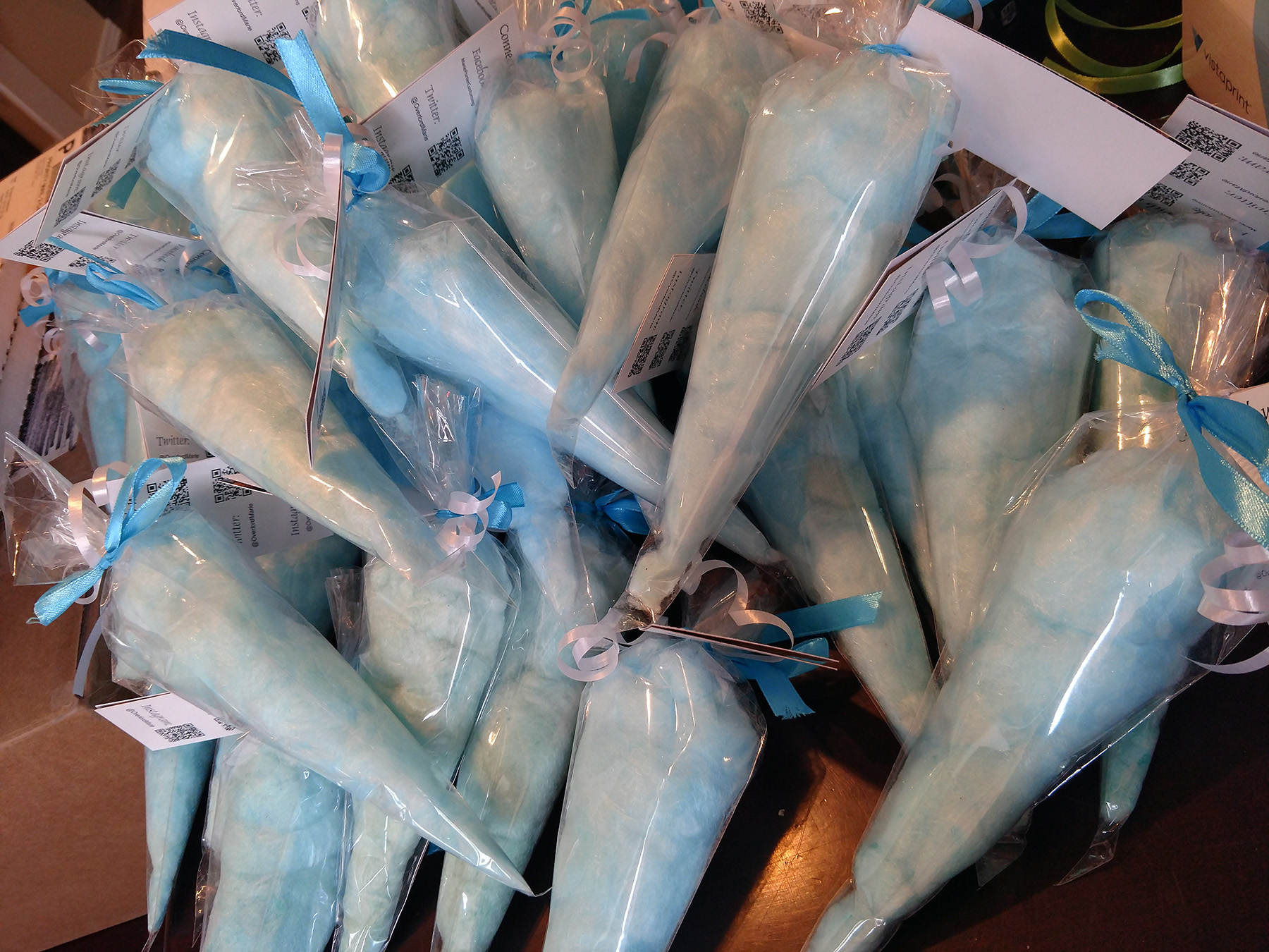 A pile of large clear frosting bags stuffed with blue cotton candy.