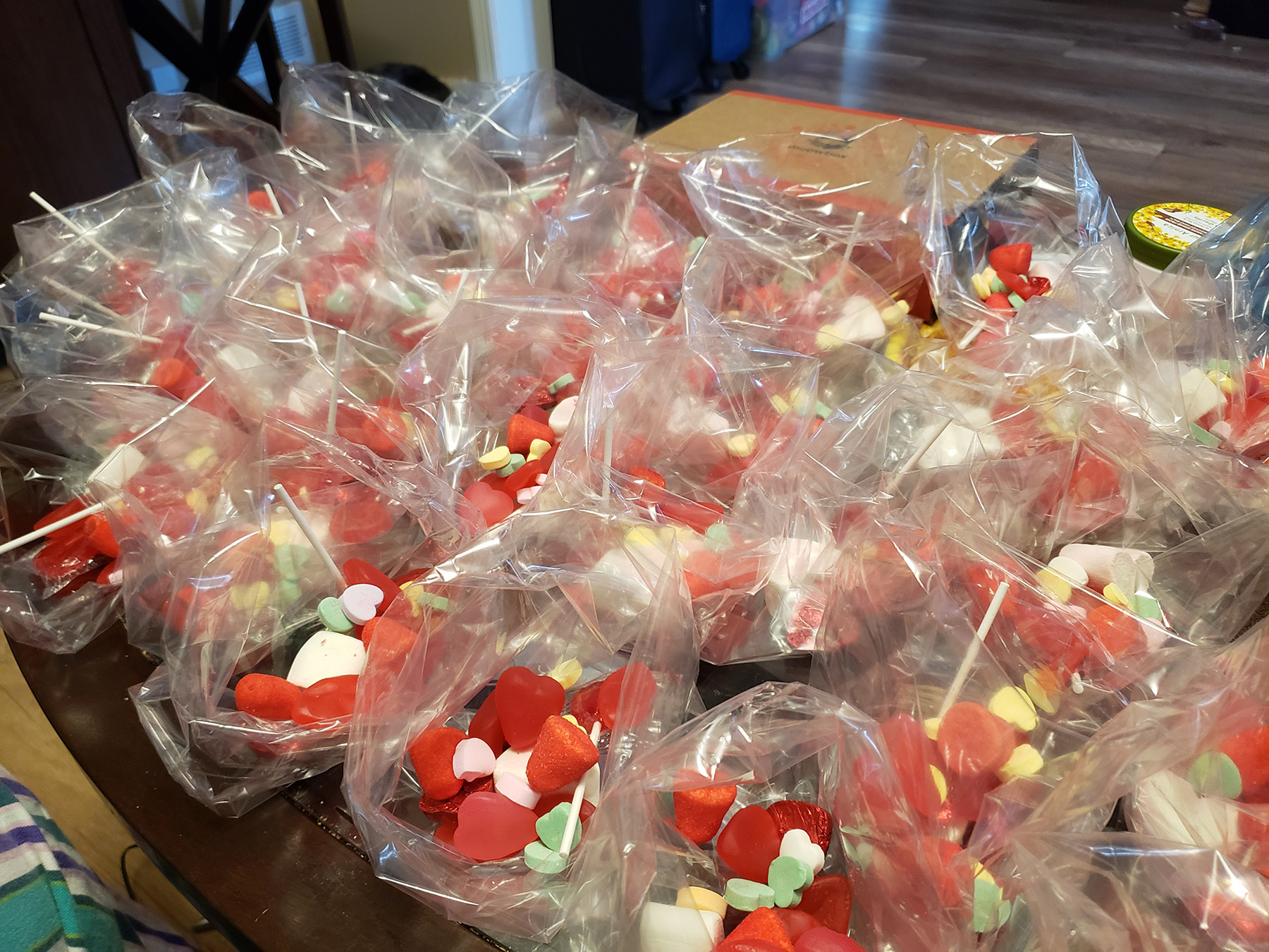 A pile of clear plastic goodie bags filled with red and white candy.