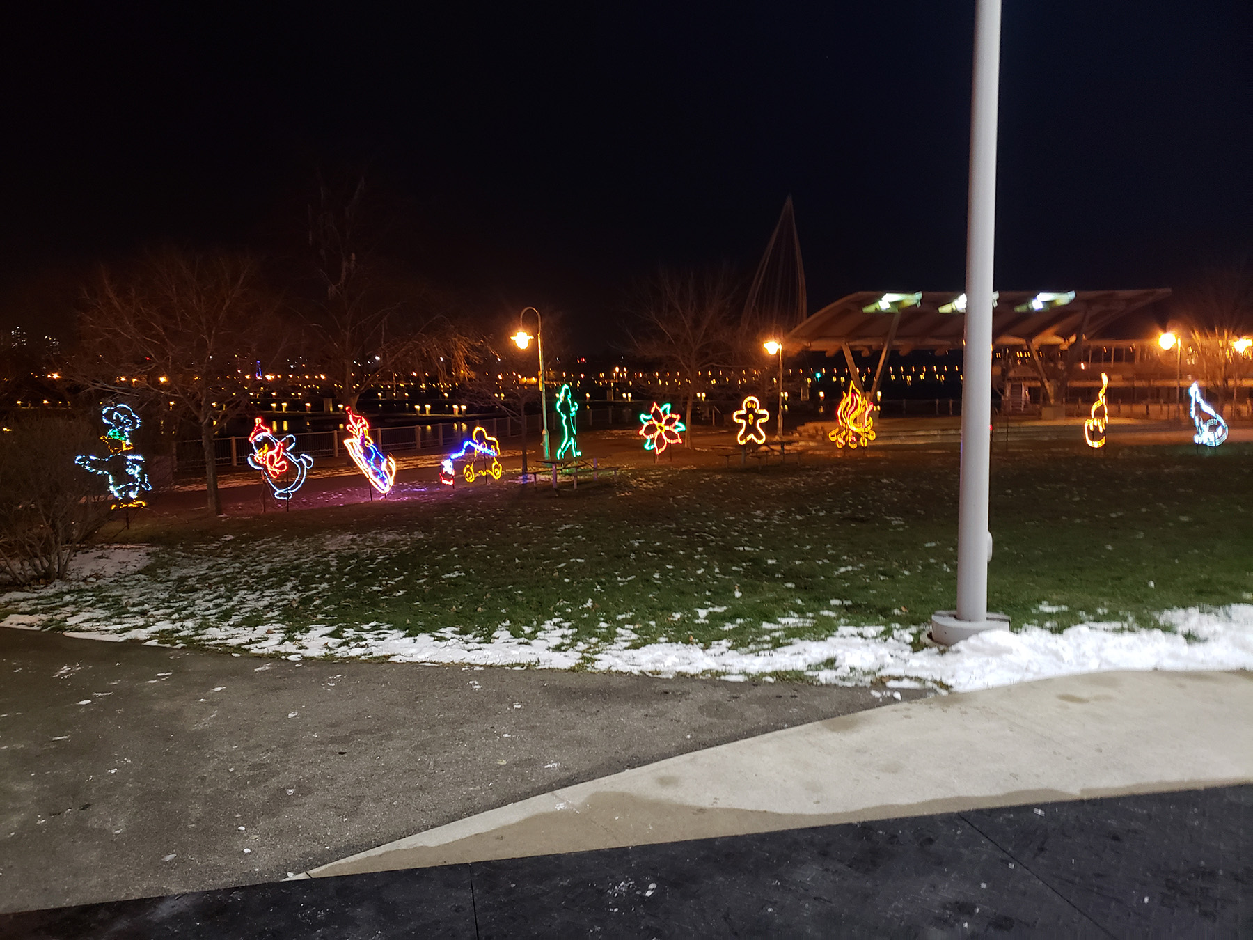 A line of lit up christmas decorations on a lawn.