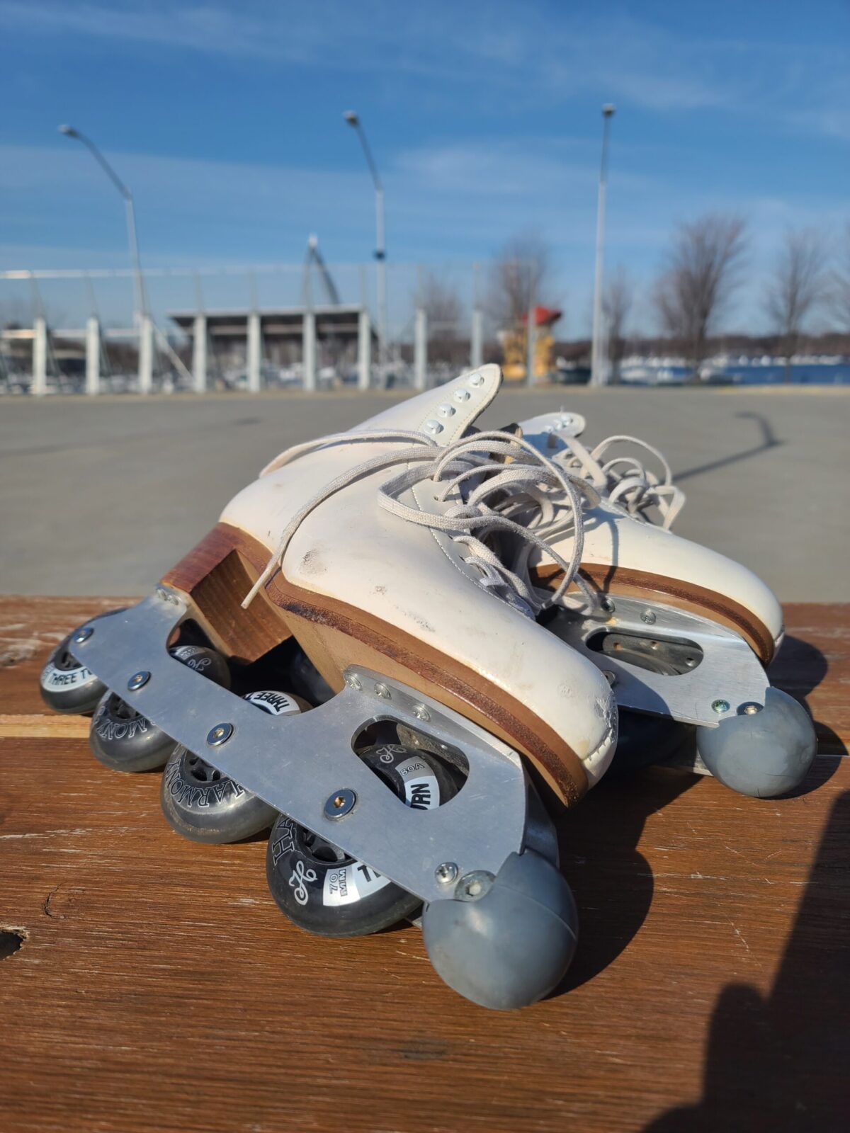 A pair of inline roller skates on a picnic table.