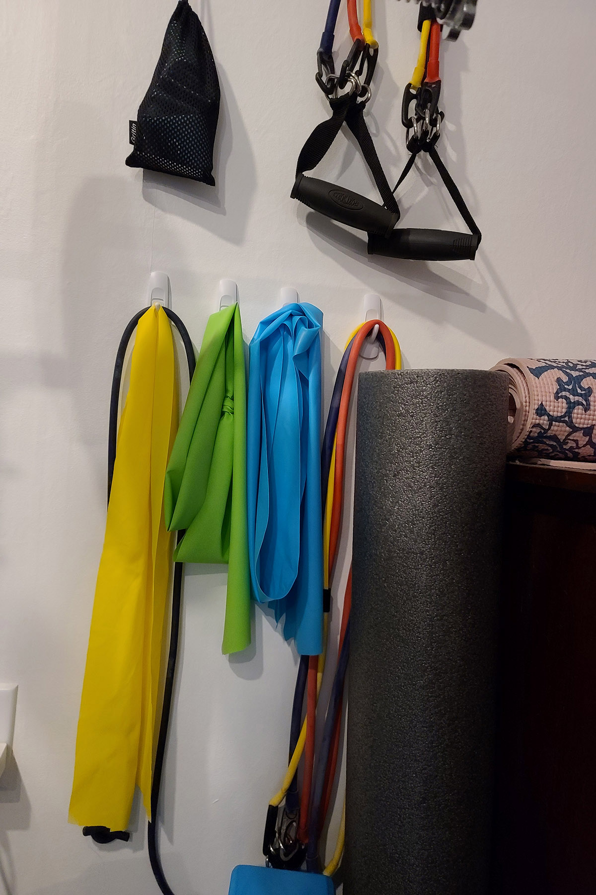 Several yoga therapy bands hanging from hooks on a wall.